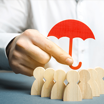 A hand holds a red umbrella above wooden figures, symbolizing protection and support for a group, emphasizing the theme of safeguarding.